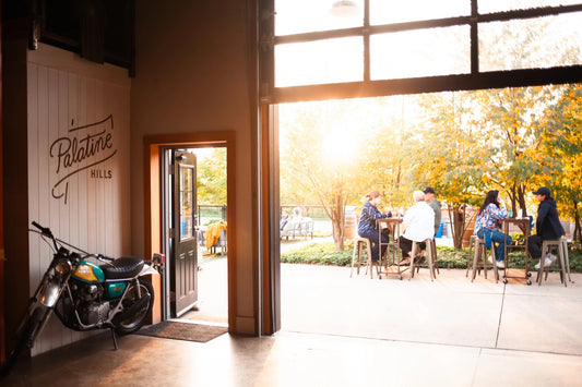 The open doors of the Palatine Hills tasting room, with guests at tables on the patio