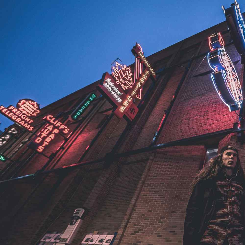 Neon signs at night in alberta street, visible maple and canadian logo