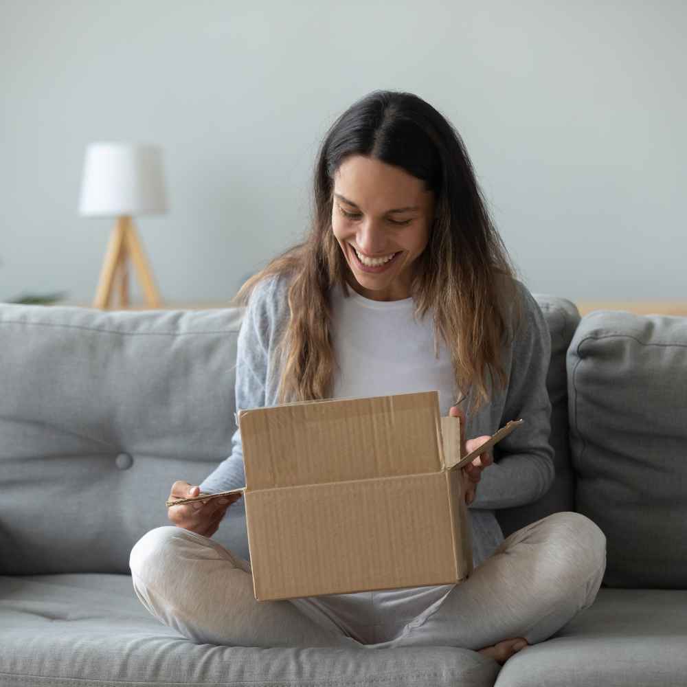 Woman opening a wine gift basket delivery