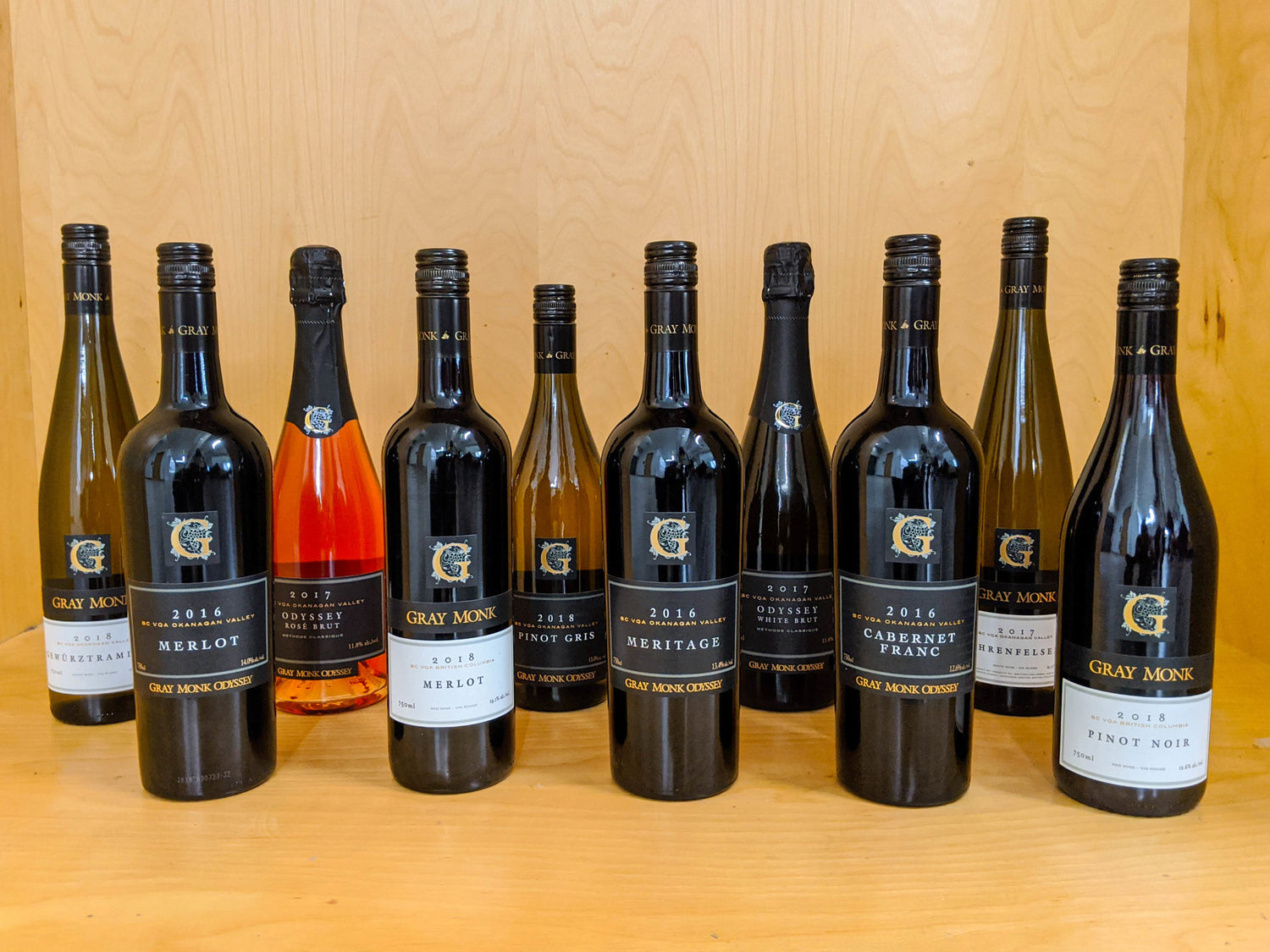 Gray Monk wine bottles displayed on a rustic table for tasting