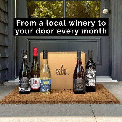 Wine bottles and a box on a doormat with text about a wine club service.