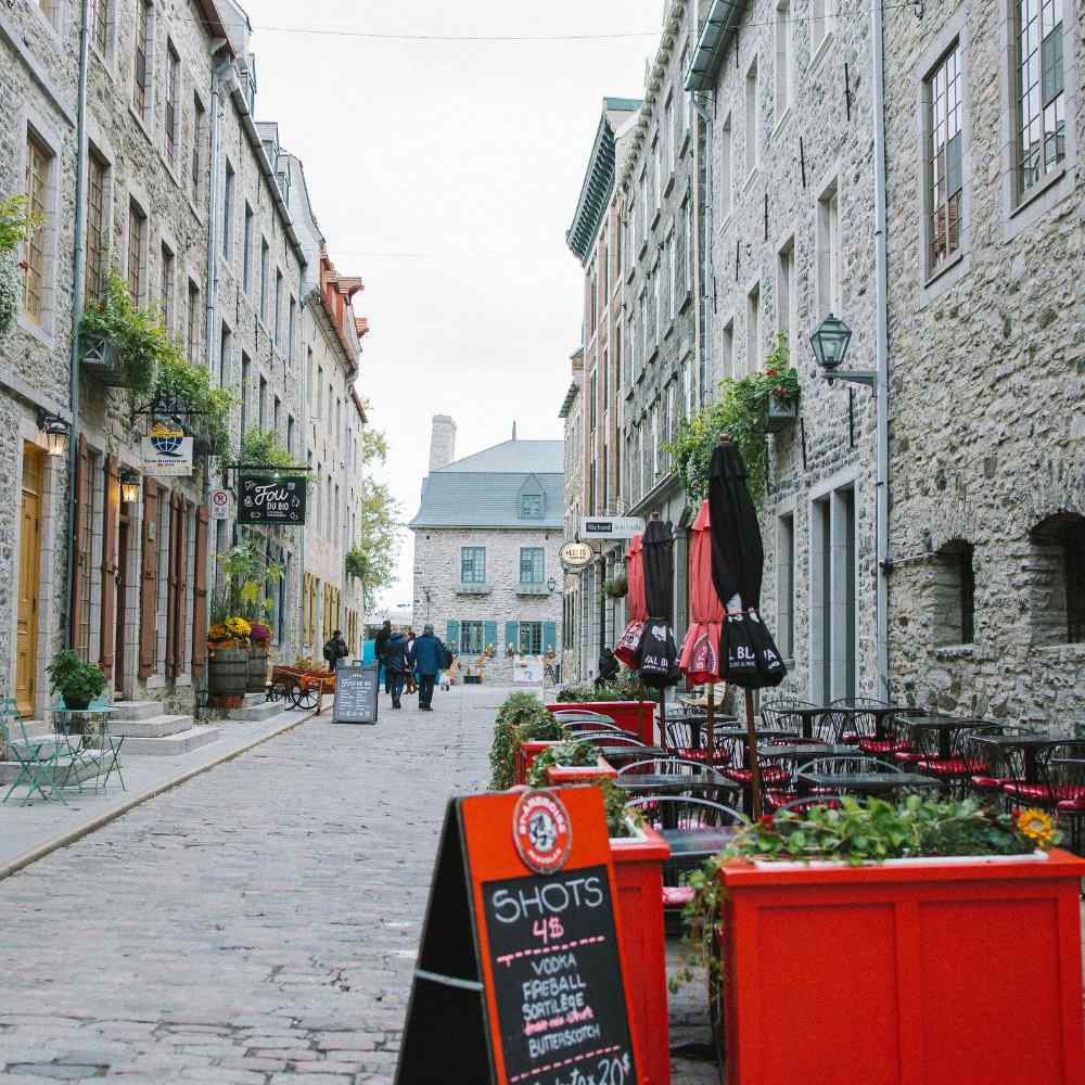 Old stone street in quebec with restaurants serving food