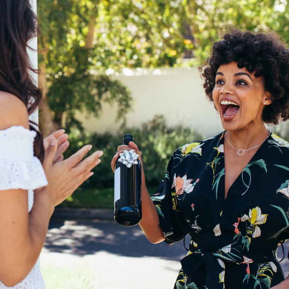 Women with a red wine gift subscription bottle