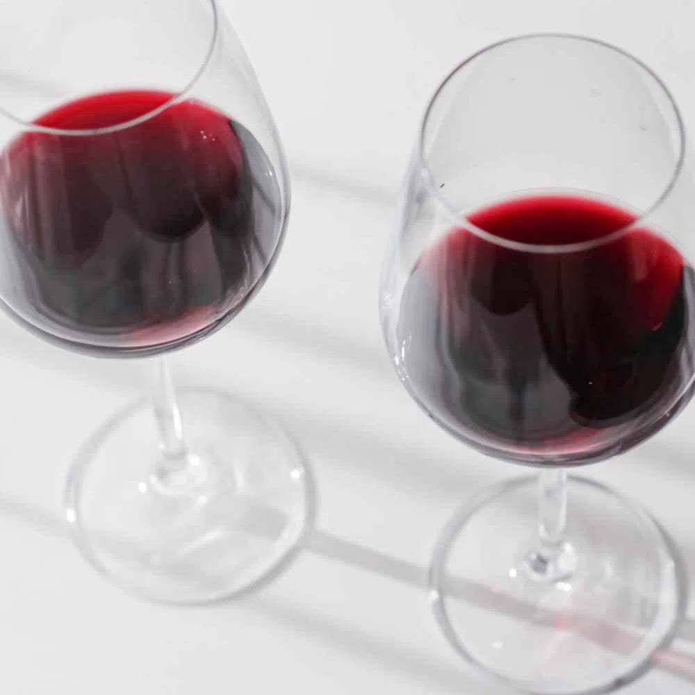 Closeup view of two red wine glasses half full