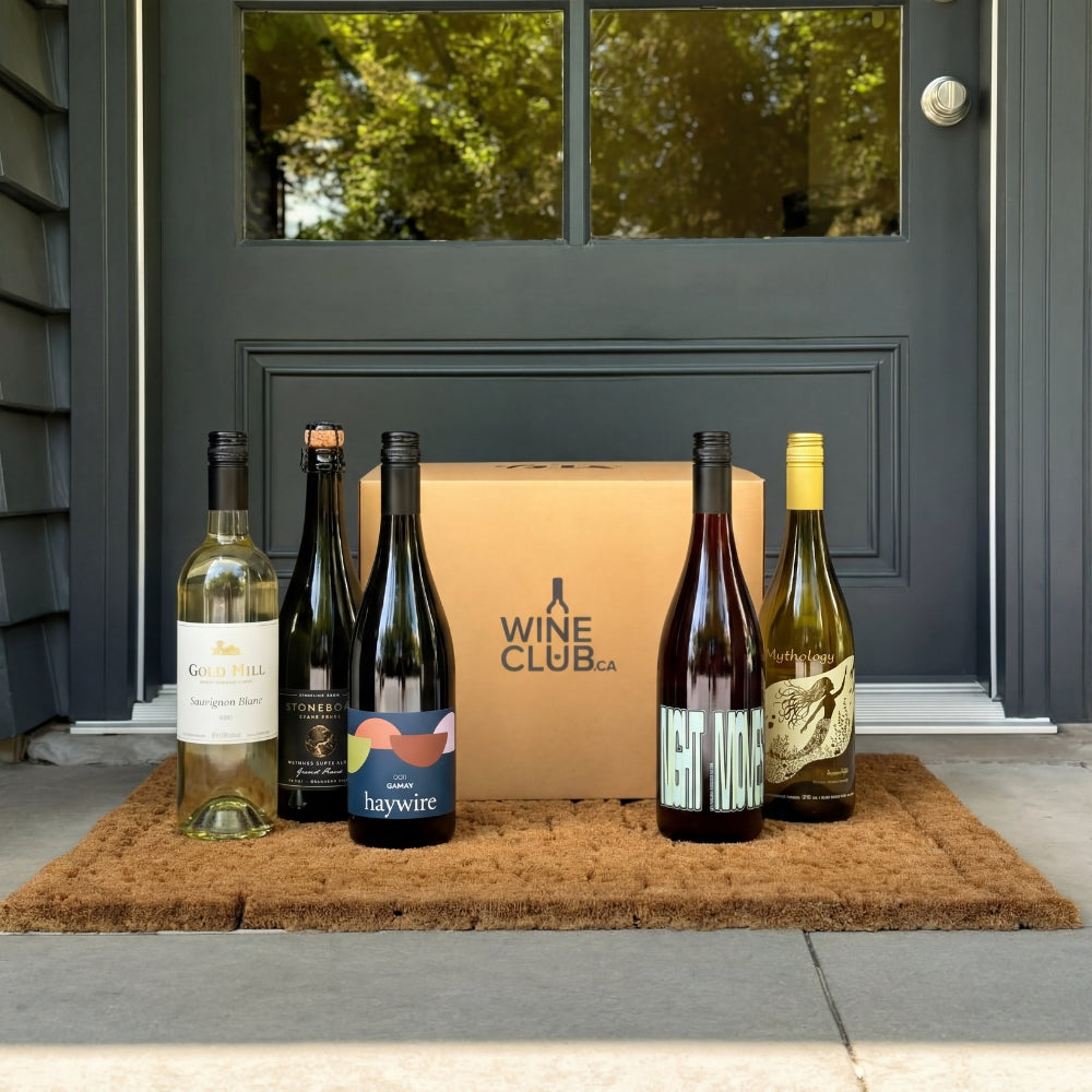 Wine bottles and a box on a doormat in front of a door