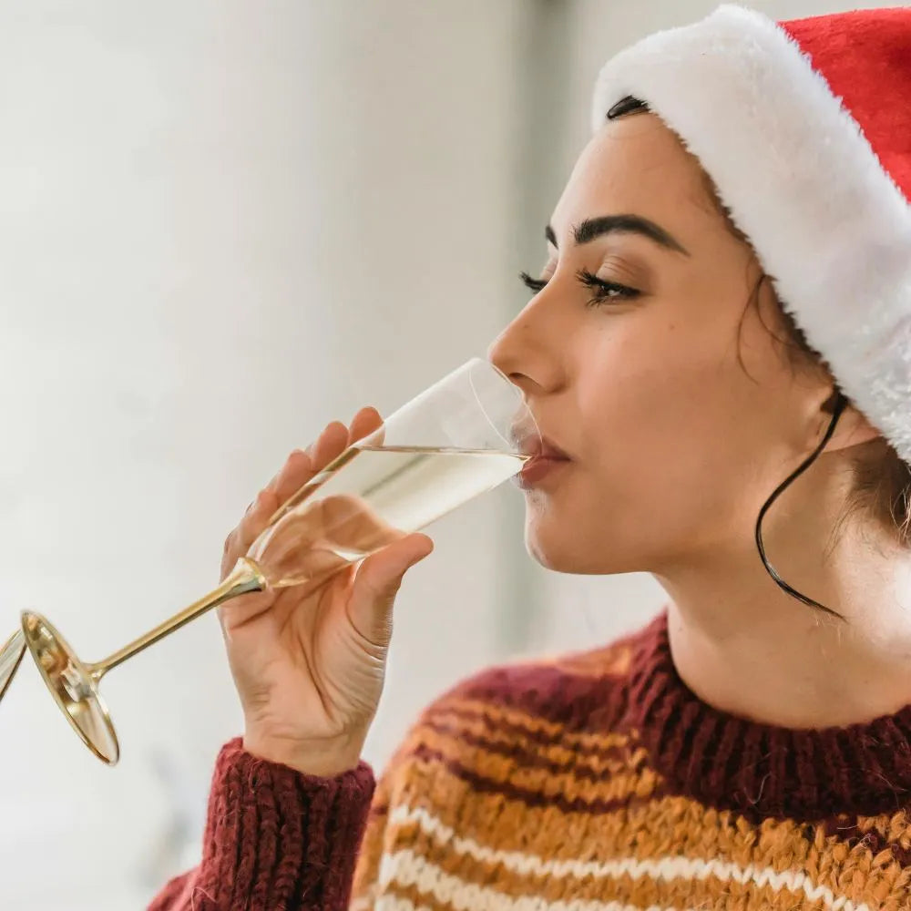 Woman in gifting festive drinking champaigne or sparkling wine
